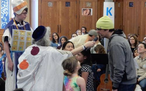 In the photo above, a Shabbat School student is being clothed as the Kohen HaGadol during a Torah story enactment.  